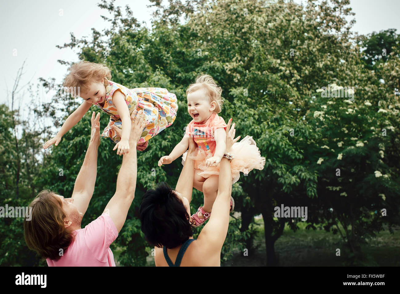 parents throwing kids Stock Photo