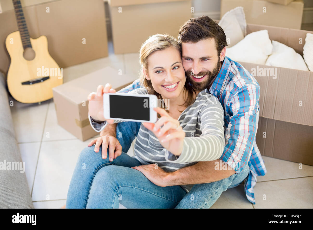 Couple sitting on floor with mobile hi-res stock photography and images ...