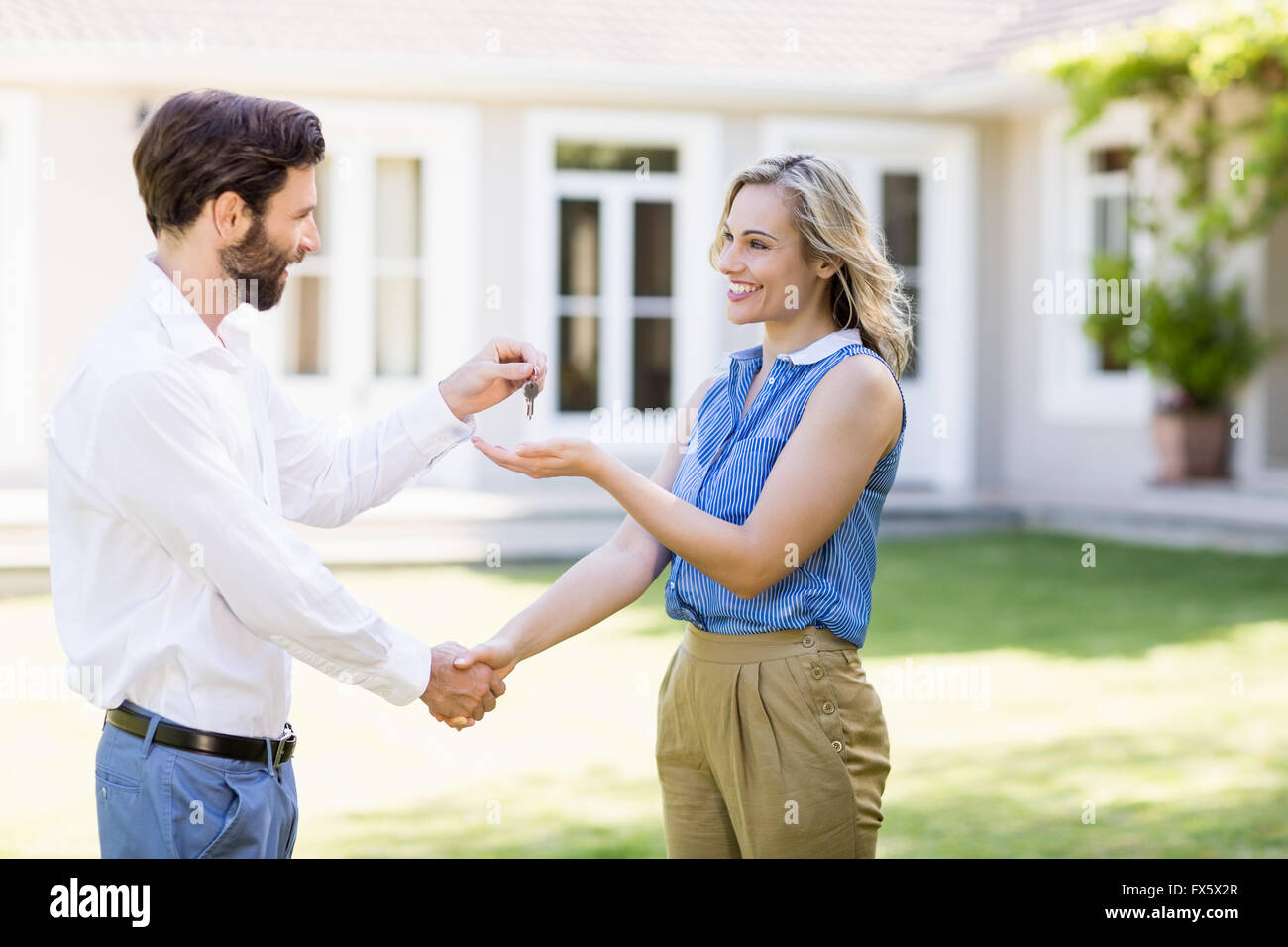 Real estate agent giving keys to woman Stock Photo - Alamy