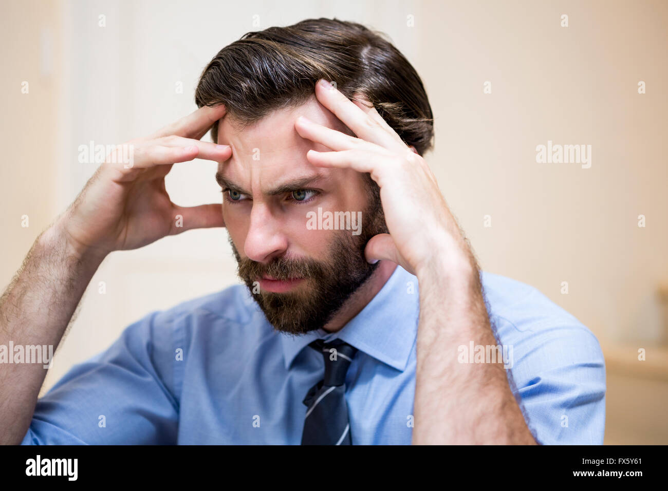 Close up of tensed man with hands on forehead Stock Photo