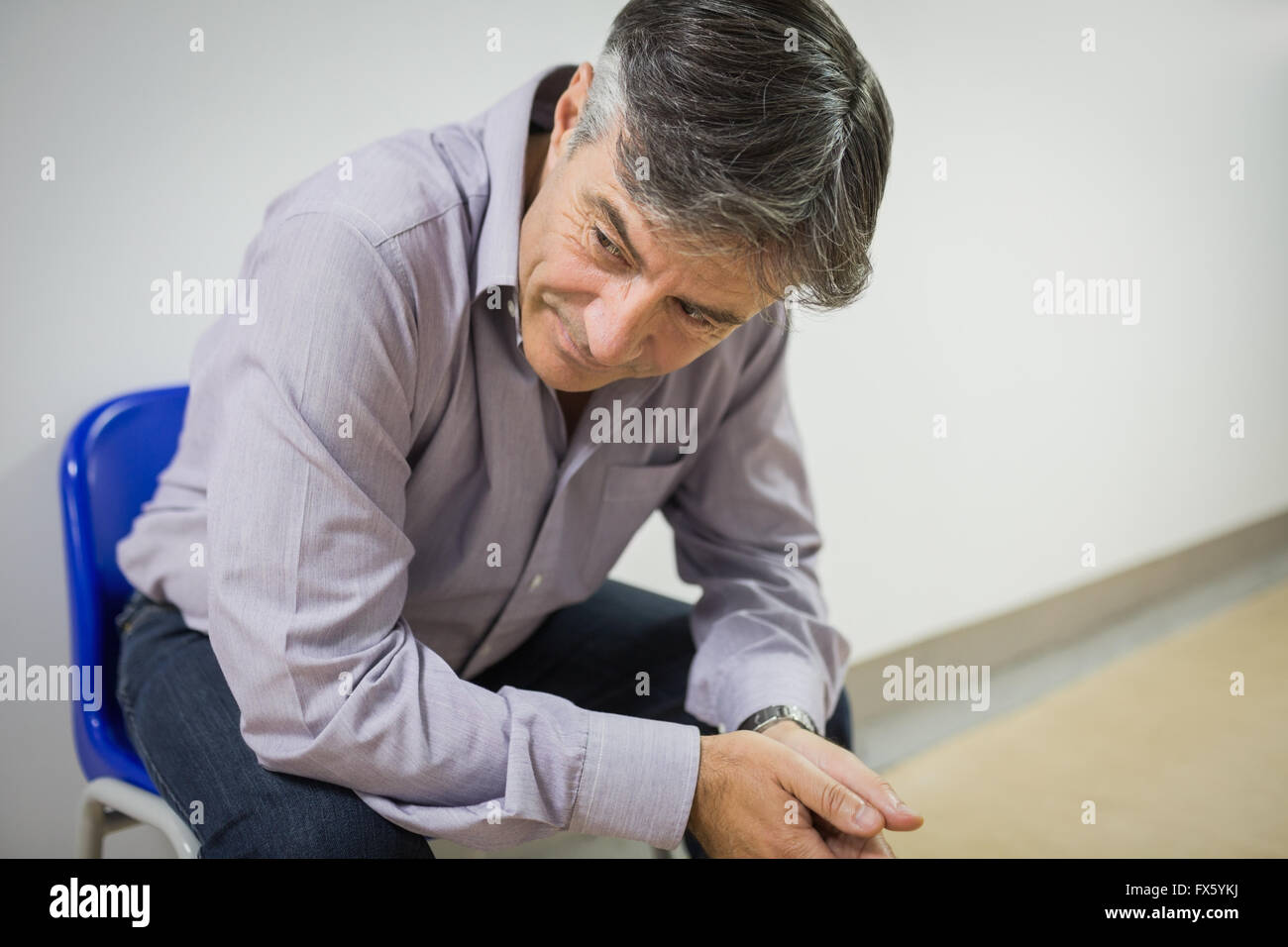 Thoughtful professor sitting on chair Stock Photo Alamy
