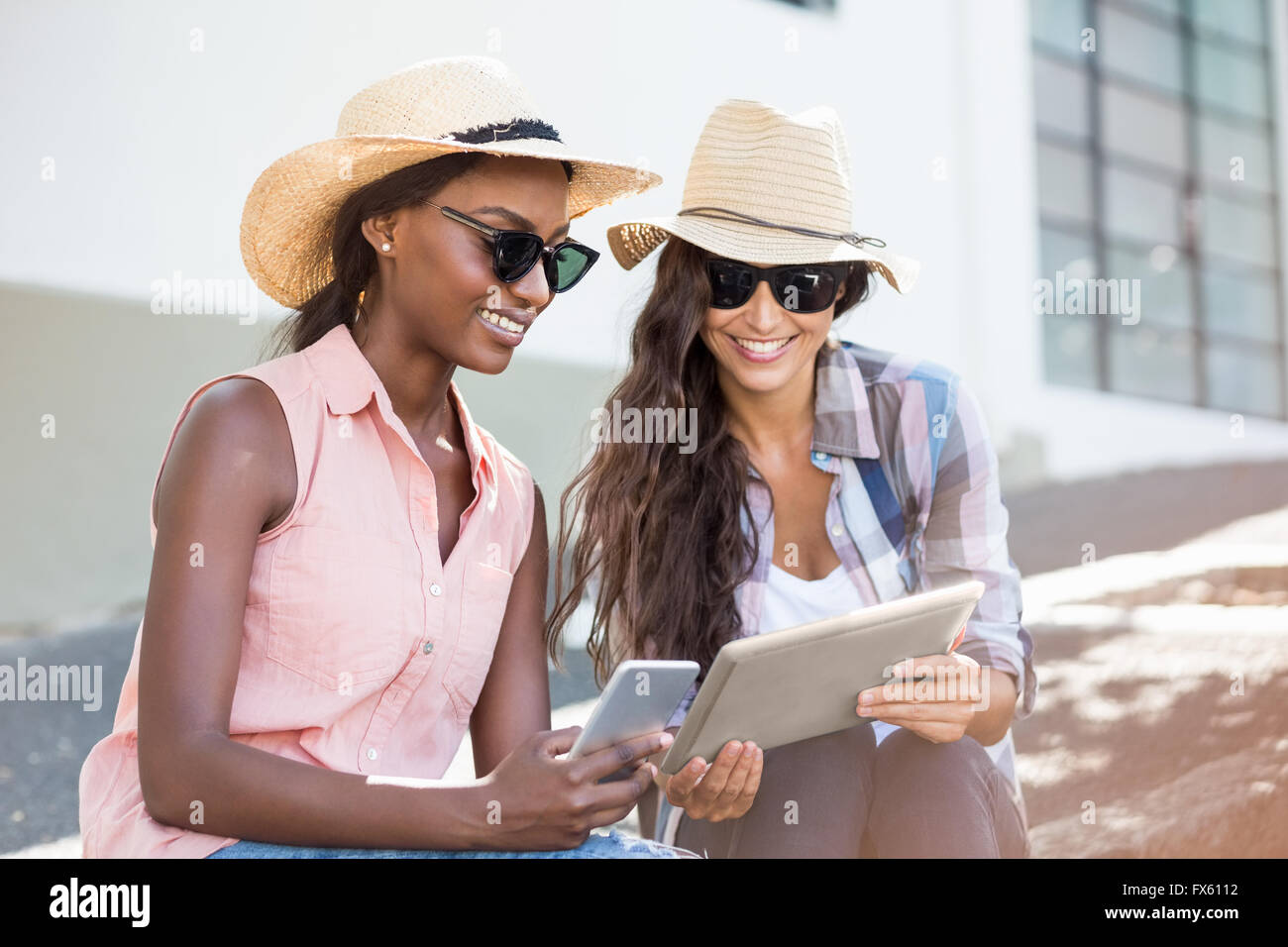 Young women using digital tablet and mobile phone Stock Photo - Alamy