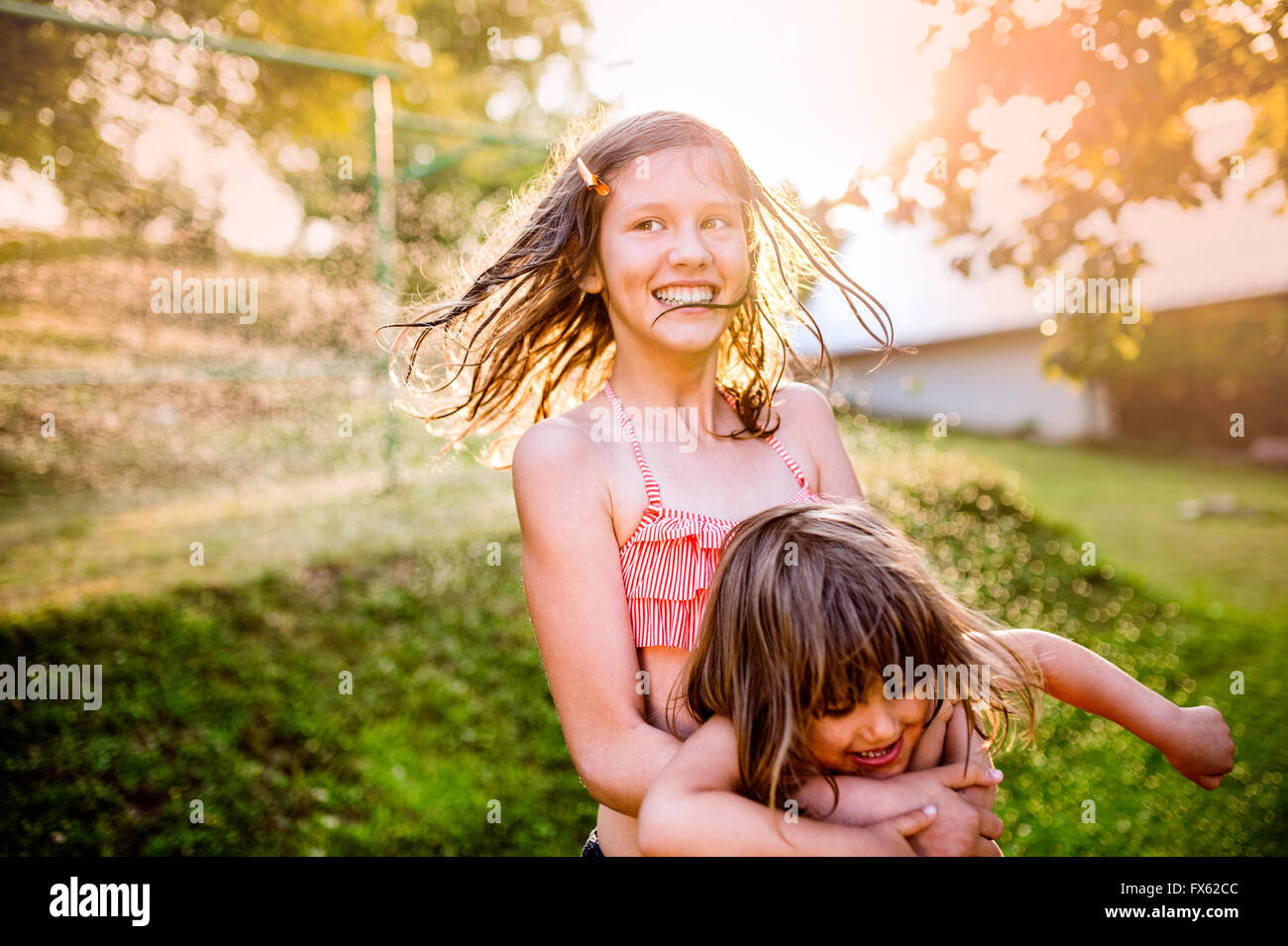 Two cute girls having fun outside in summer garden Stock Photo