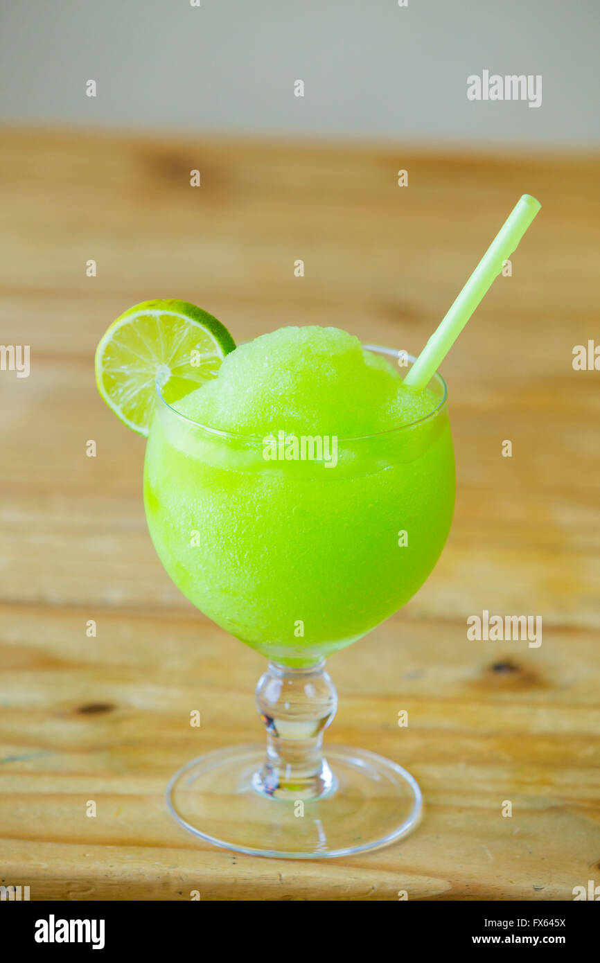 Green lime margarita at a restaurant bar with a straw. Stock Photo