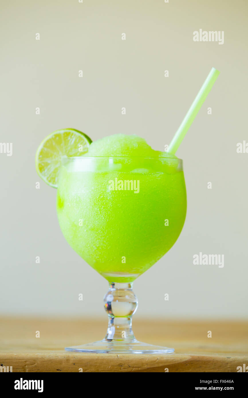 Green lime margarita at a restaurant bar with a straw. Stock Photo