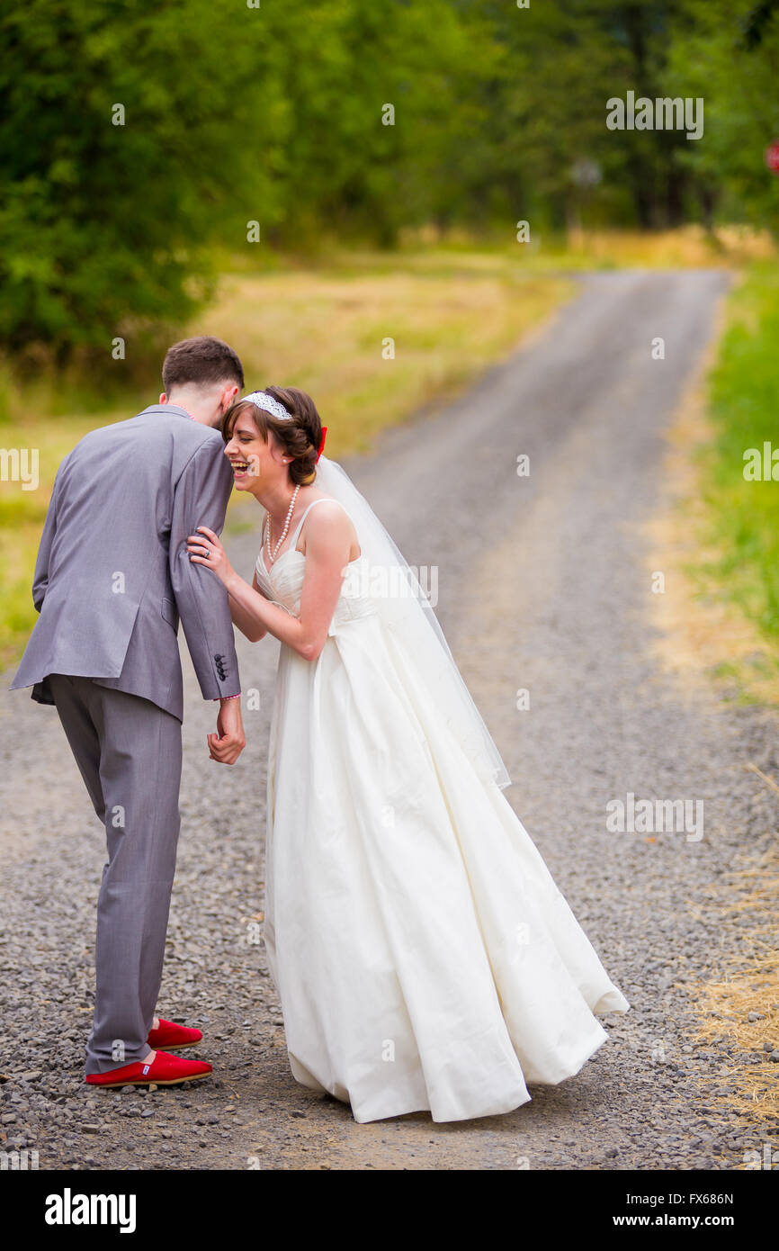 Wedding day portrait of bride and groom on an old gravel road sharing a moment before their ceremony. Stock Photo