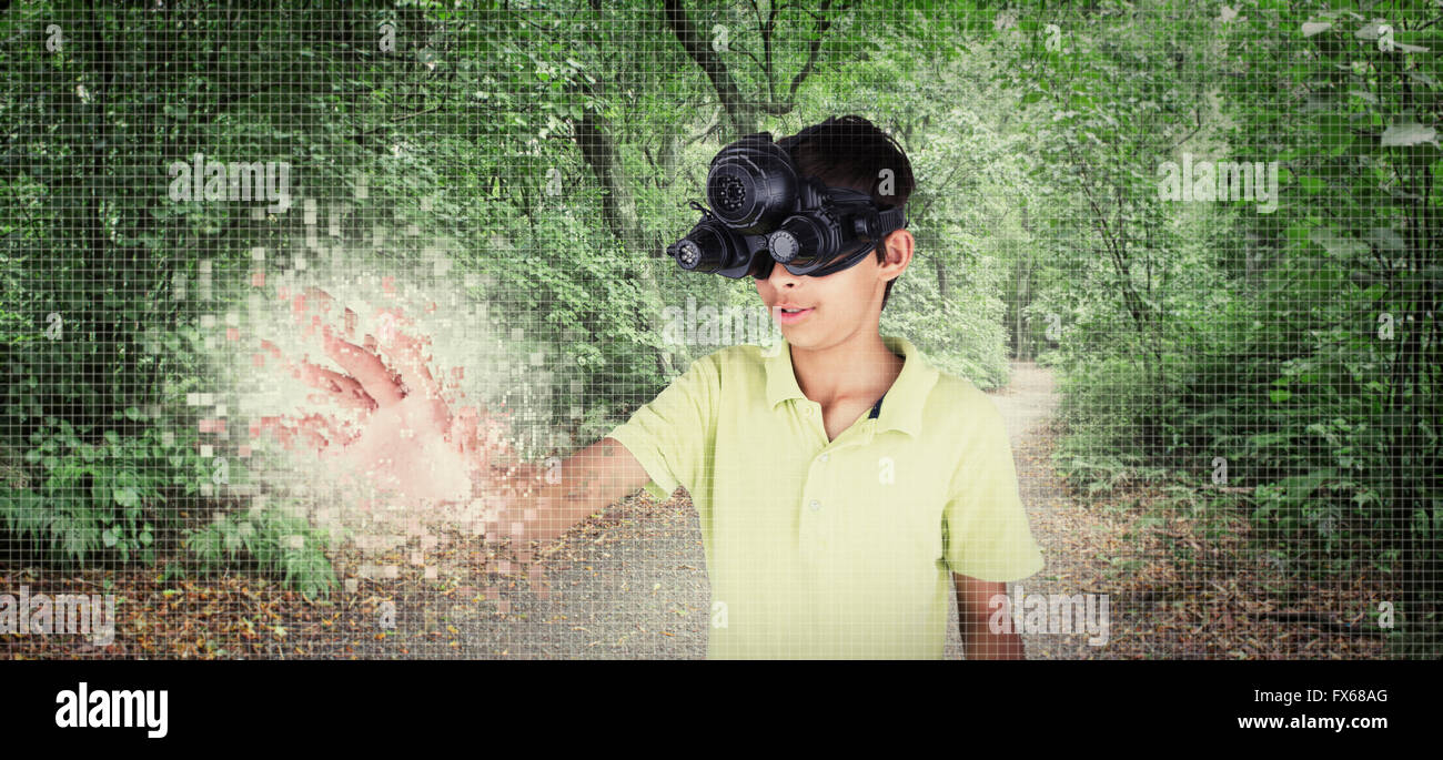 Mixed race boy wearing virtual reality goggles in remote forest Stock Photo