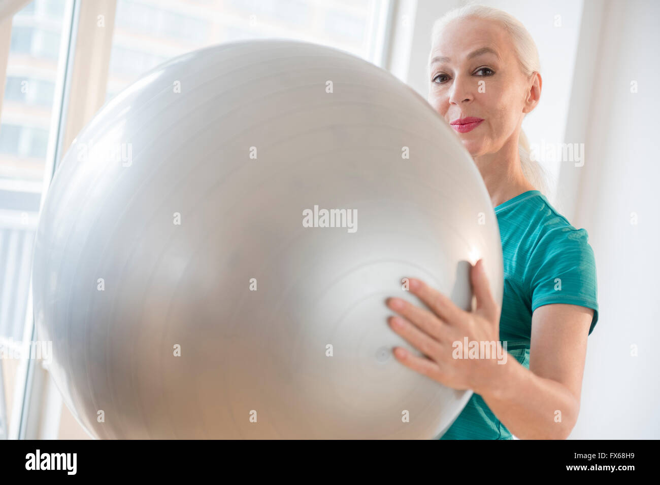 Caucasian woman holding fitness ball Stock Photo - Alamy