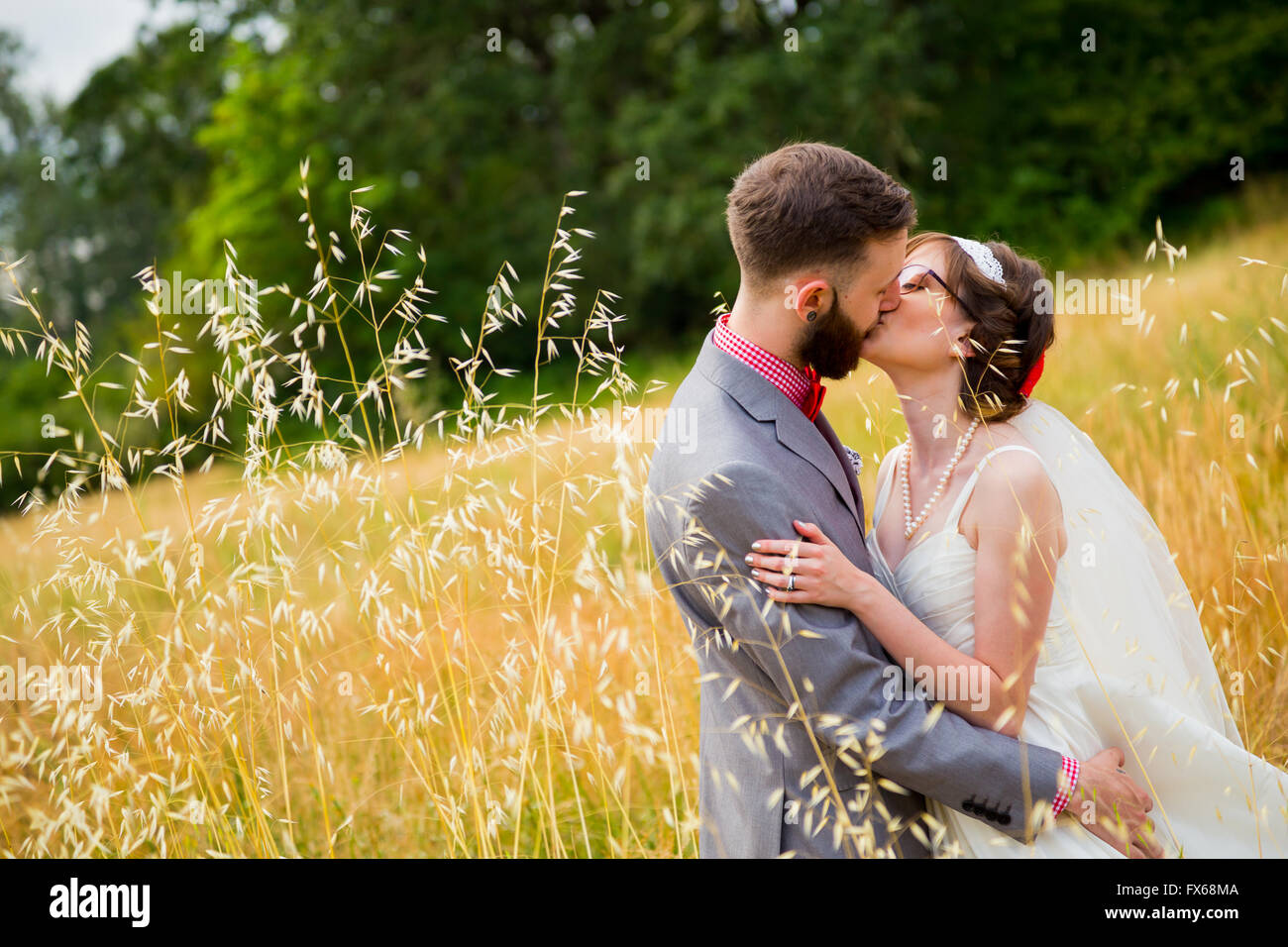Bride and groom kissing in a field on their wedding day Stock Photo - Alamy