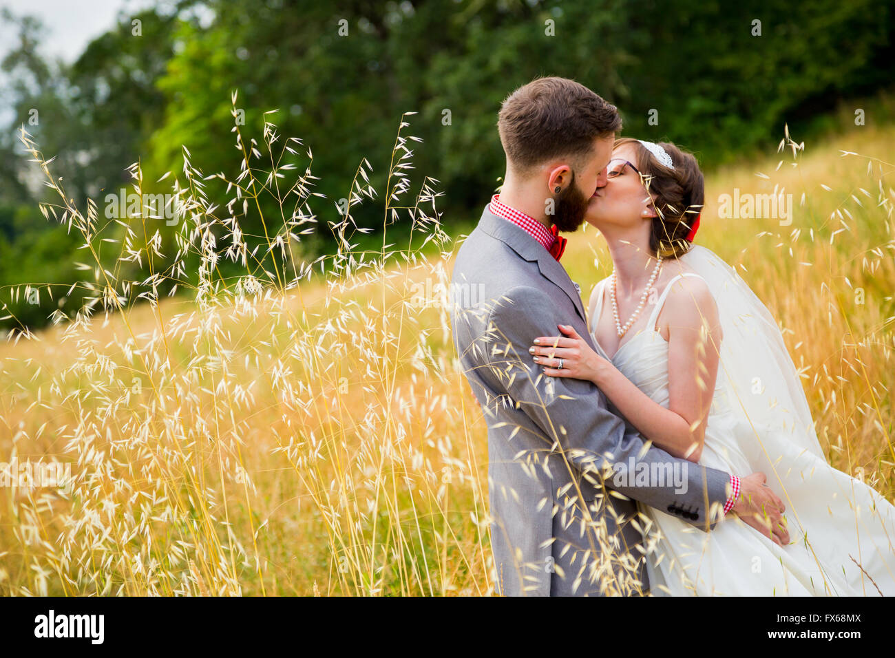 Bride and groom kissing in a field on their wedding day Stock Photo - Alamy
