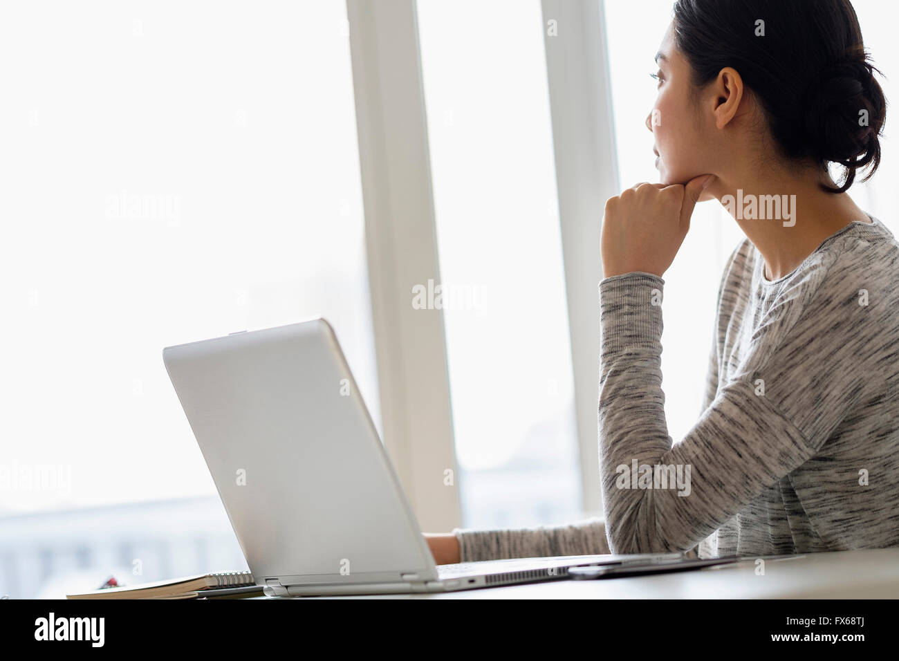 Hispanic woman sitting at laptop Stock Photo