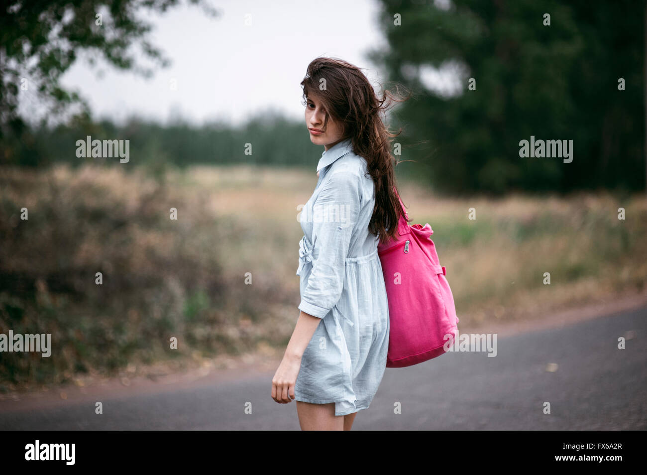 Caucasian woman walking on rural road Stock Photo