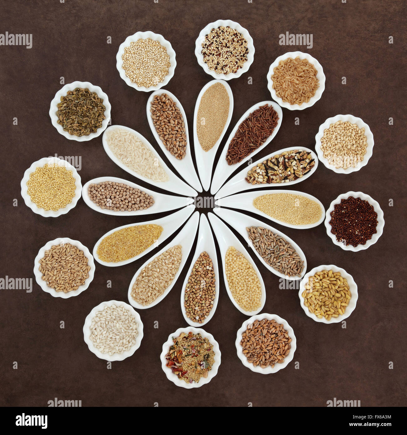 Grain and cereal food selection in porcelain dishes over lokta paper background. Stock Photo