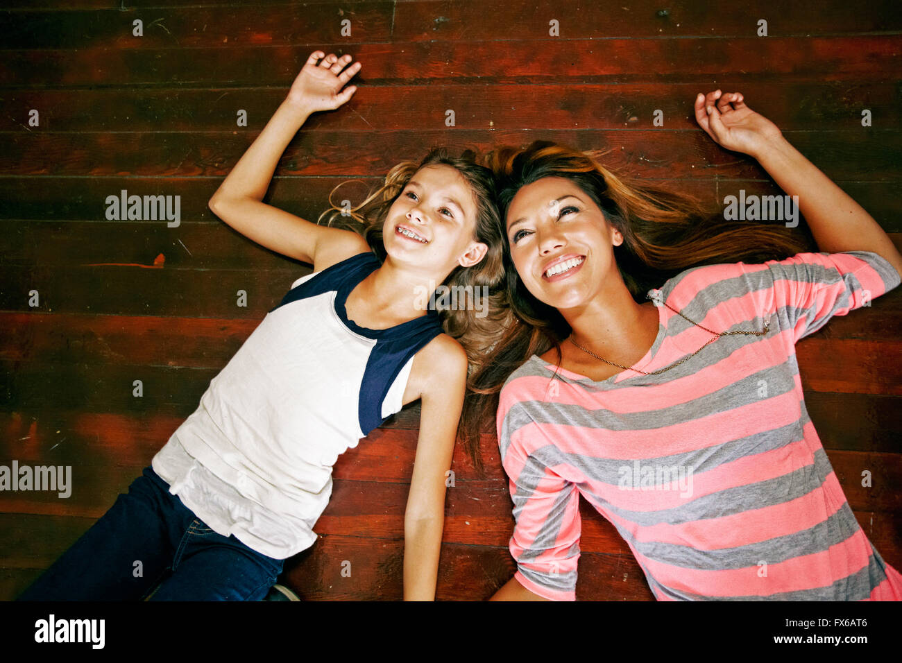 Native American mother and daughter laying on floor Stock Photo