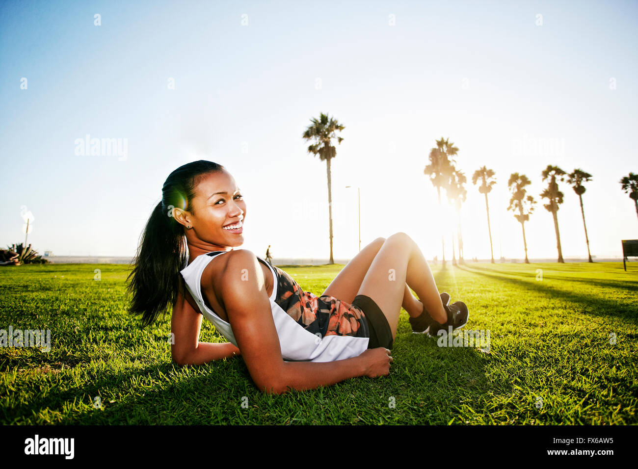 Mixed race athlete laying in park Stock Photo Alamy