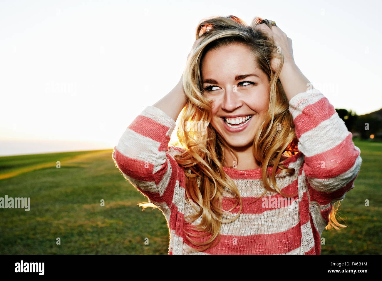 Caucasian woman smiling in field Stock Photo