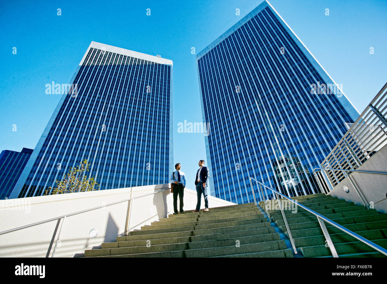 Businessmen talking under highrise buildings Stock Photo