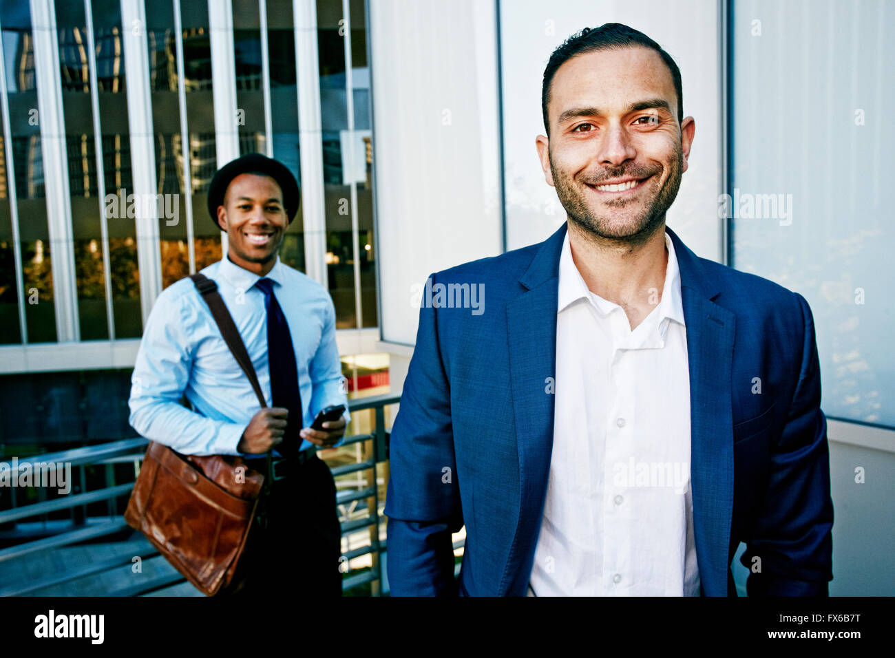 Businessmen smiling outside office building Stock Photo - Alamy