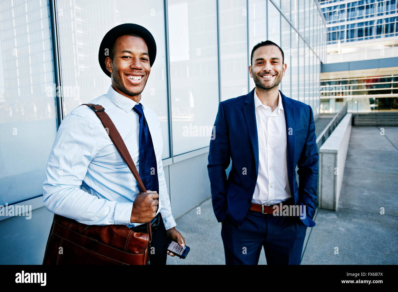 Businessmen smiling outside office building Stock Photo - Alamy