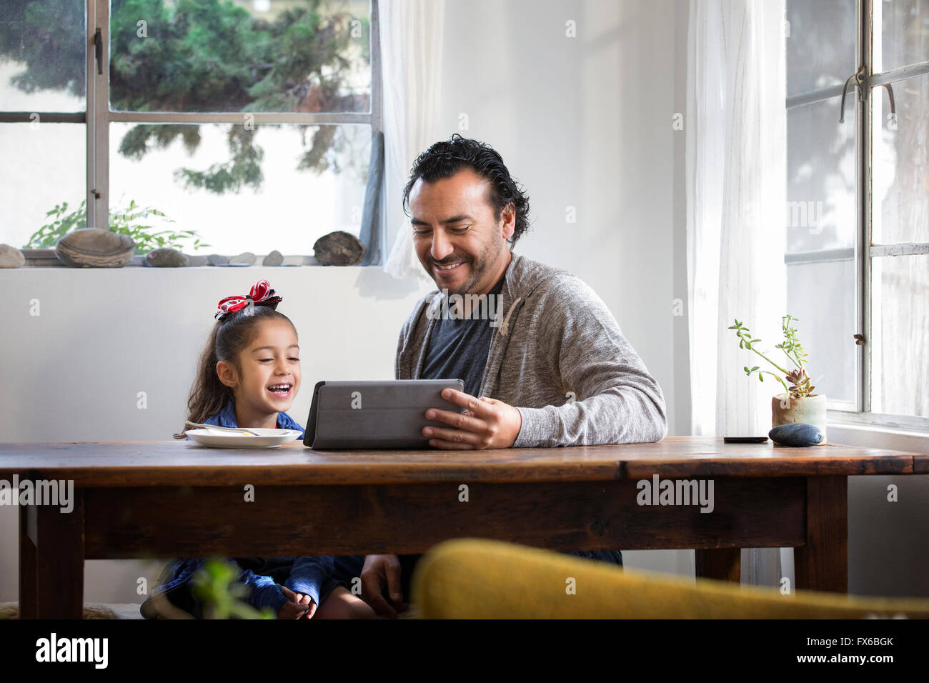 Hispanic father and daughter using digital tablet Stock Photo
