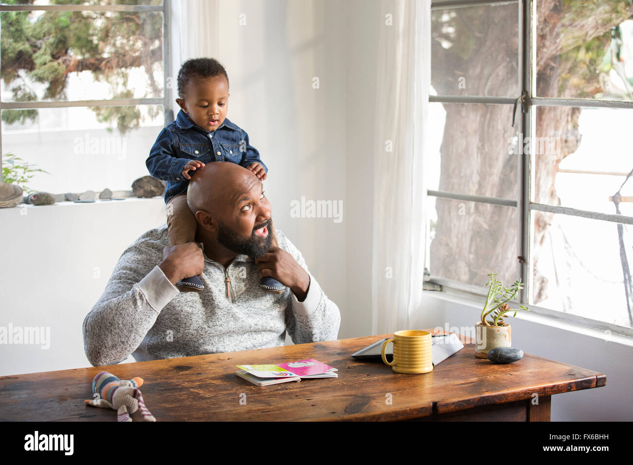 African American father holding baby son on shoulders Stock Photo