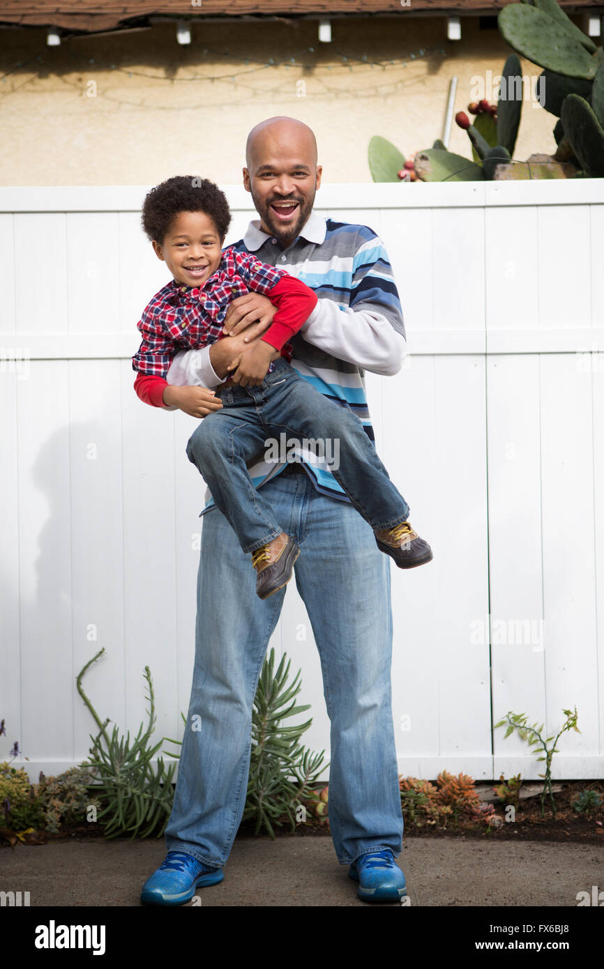 Mixed race father holding son outdoors Stock Photo