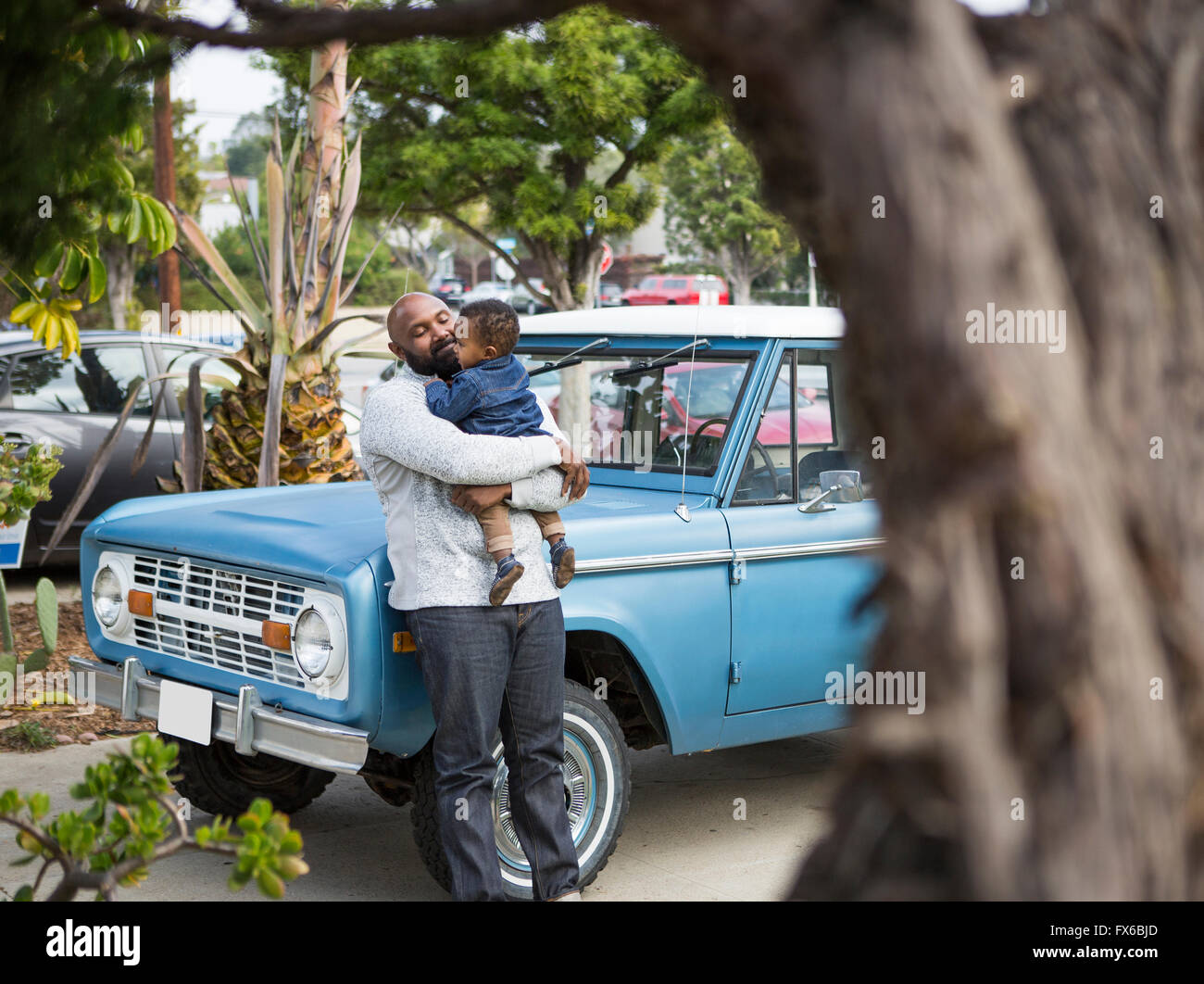 African American father holding son at truck Stock Photo