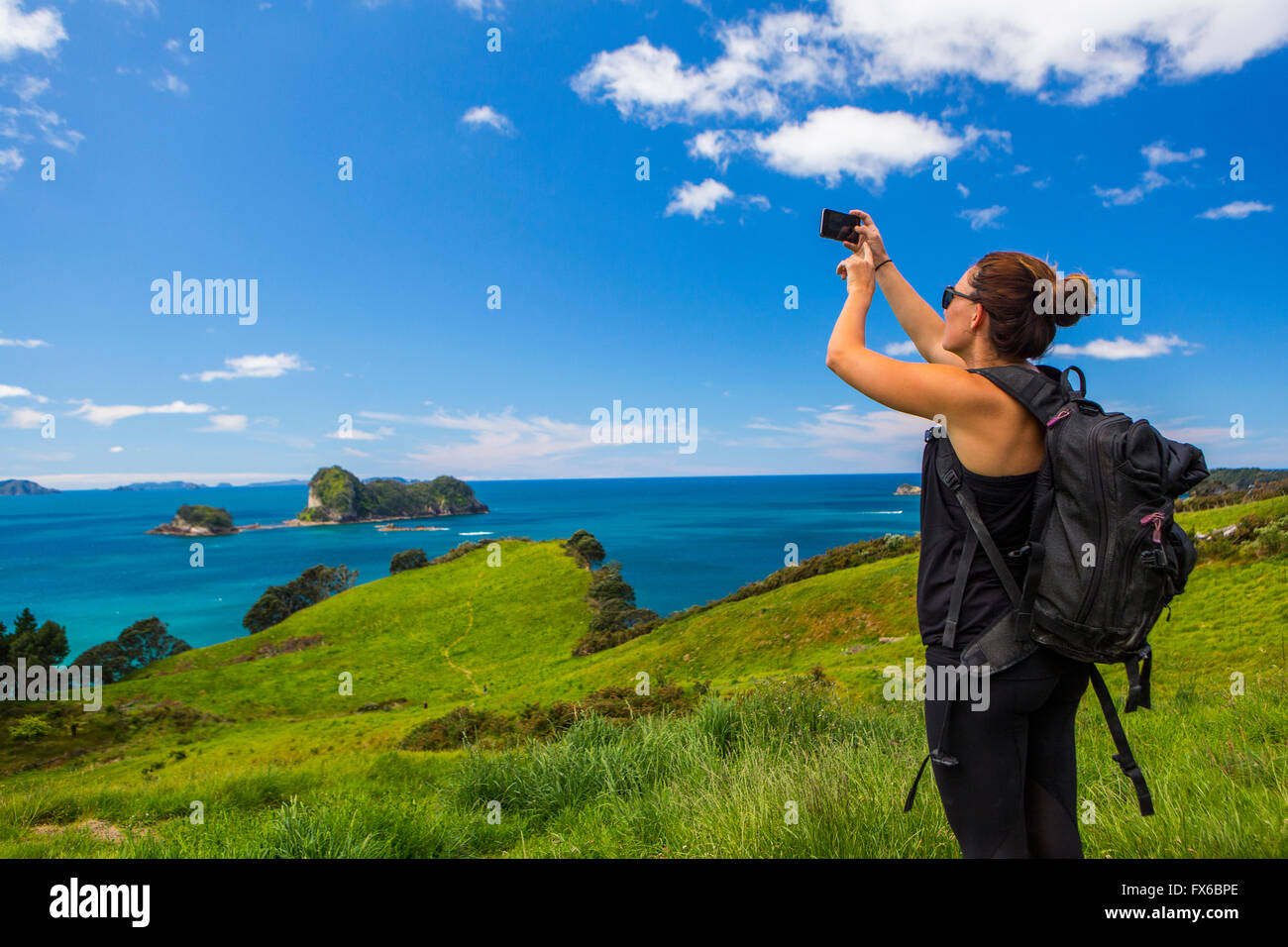Caucasian hiker photographing cliff and seascape Stock Photo - Alamy