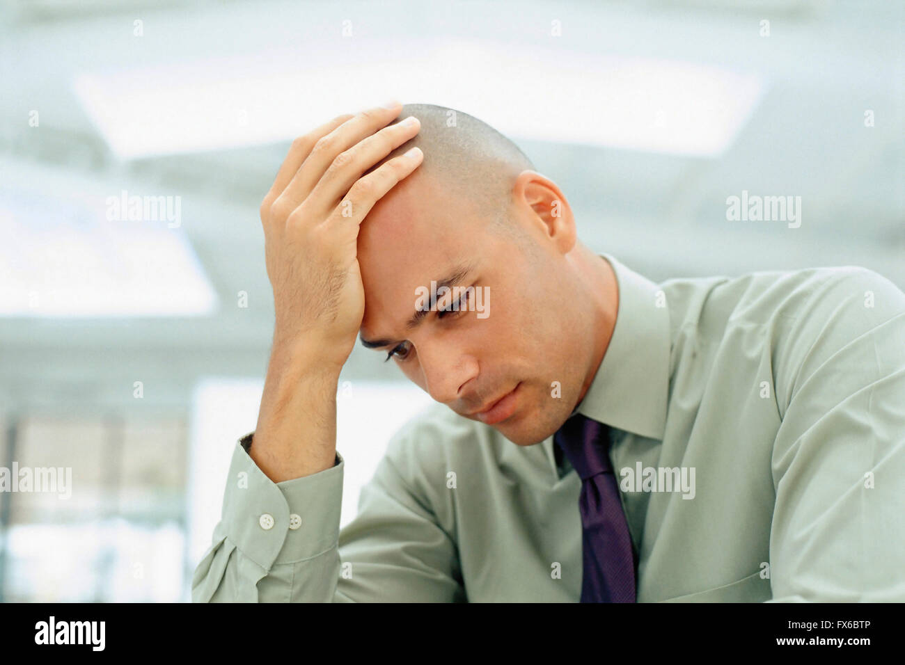Black businessman rubbing his head Stock Photo