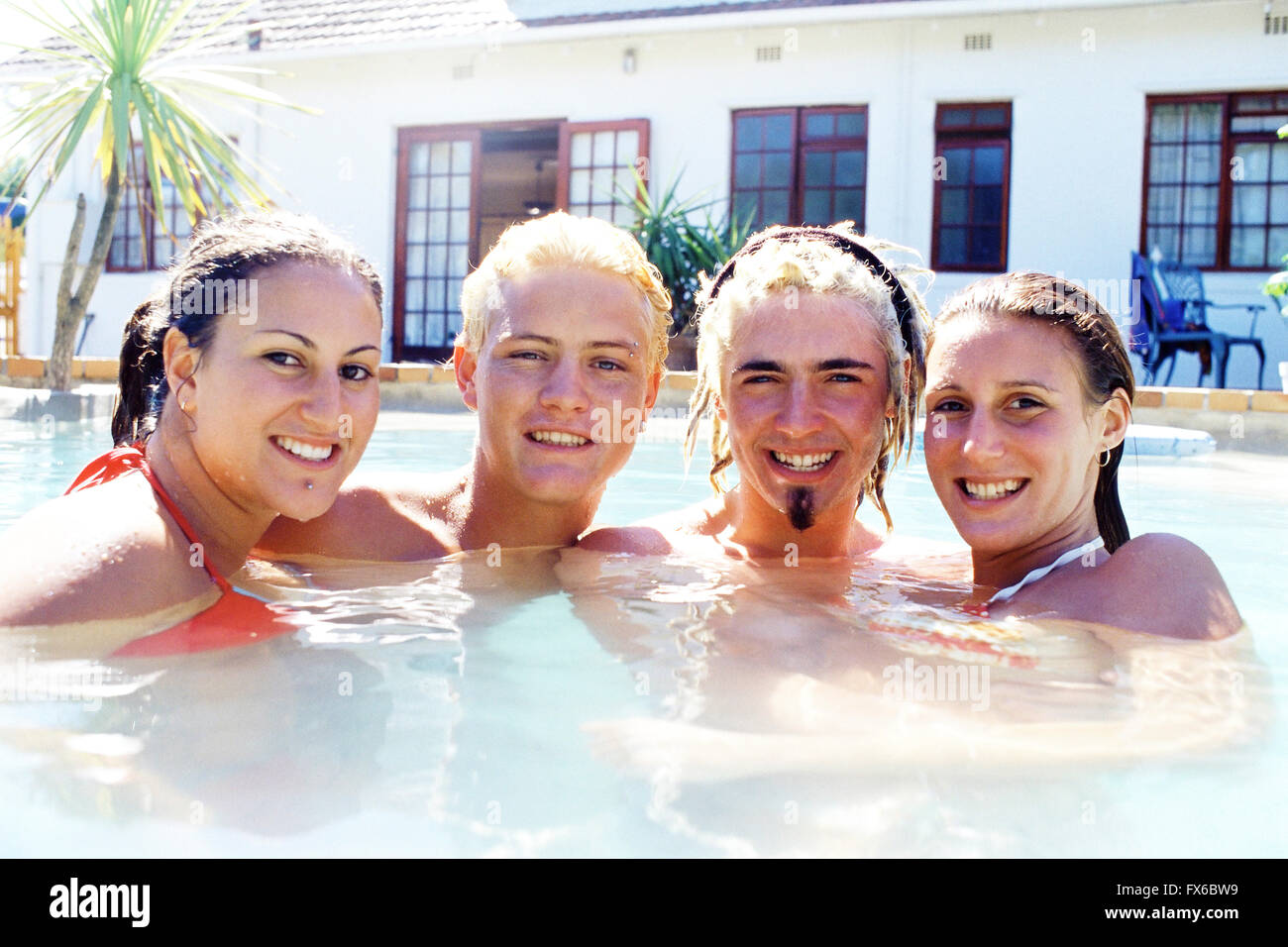 Caucasian friends smiling in swimming pool Stock Photo