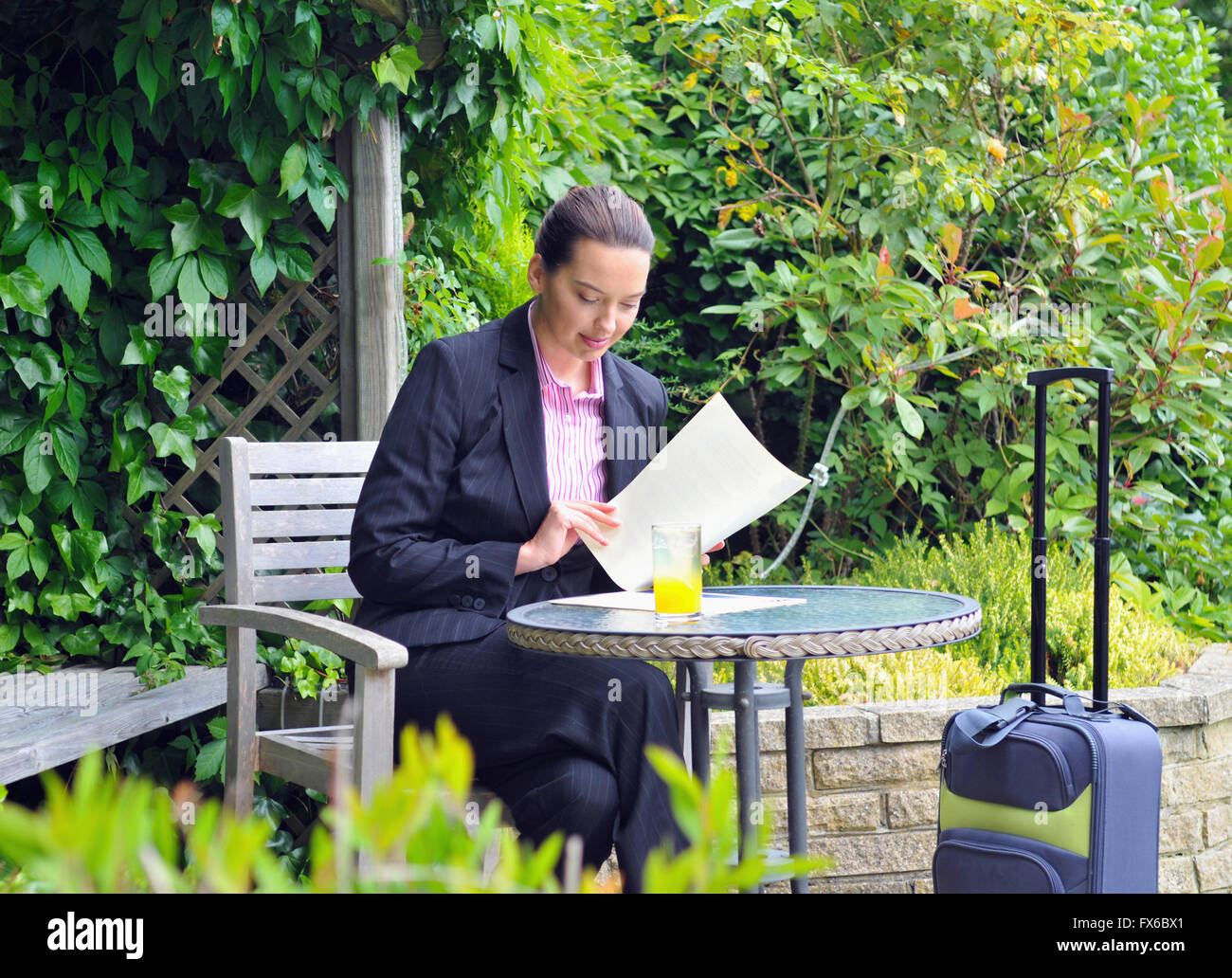 Caucasian businesswoman working in garden Stock Photo