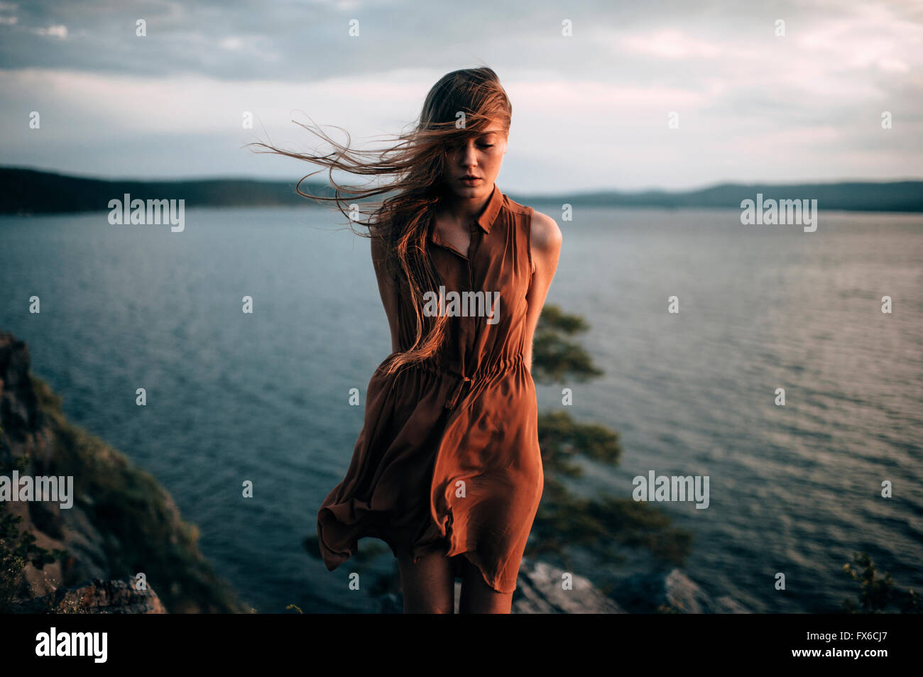 Caucasian woman standing near remote lake Stock Photo - Alamy
