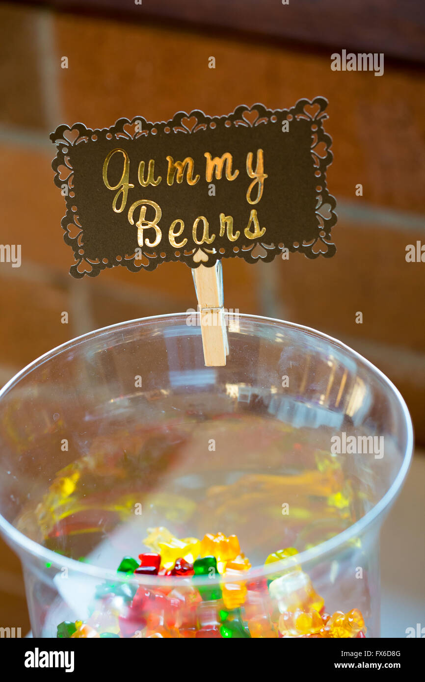 Candy bar with glass dish holds gummy bears and a custom sign showing