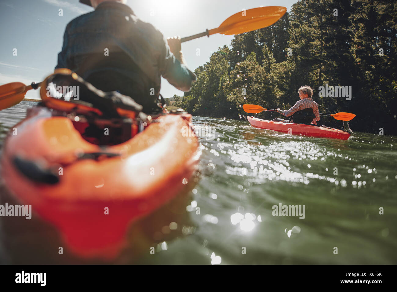 Portrait of mature woman kayaking in lake on a sunny day. Couple canoeing in a lake on  summer day. Stock Photo