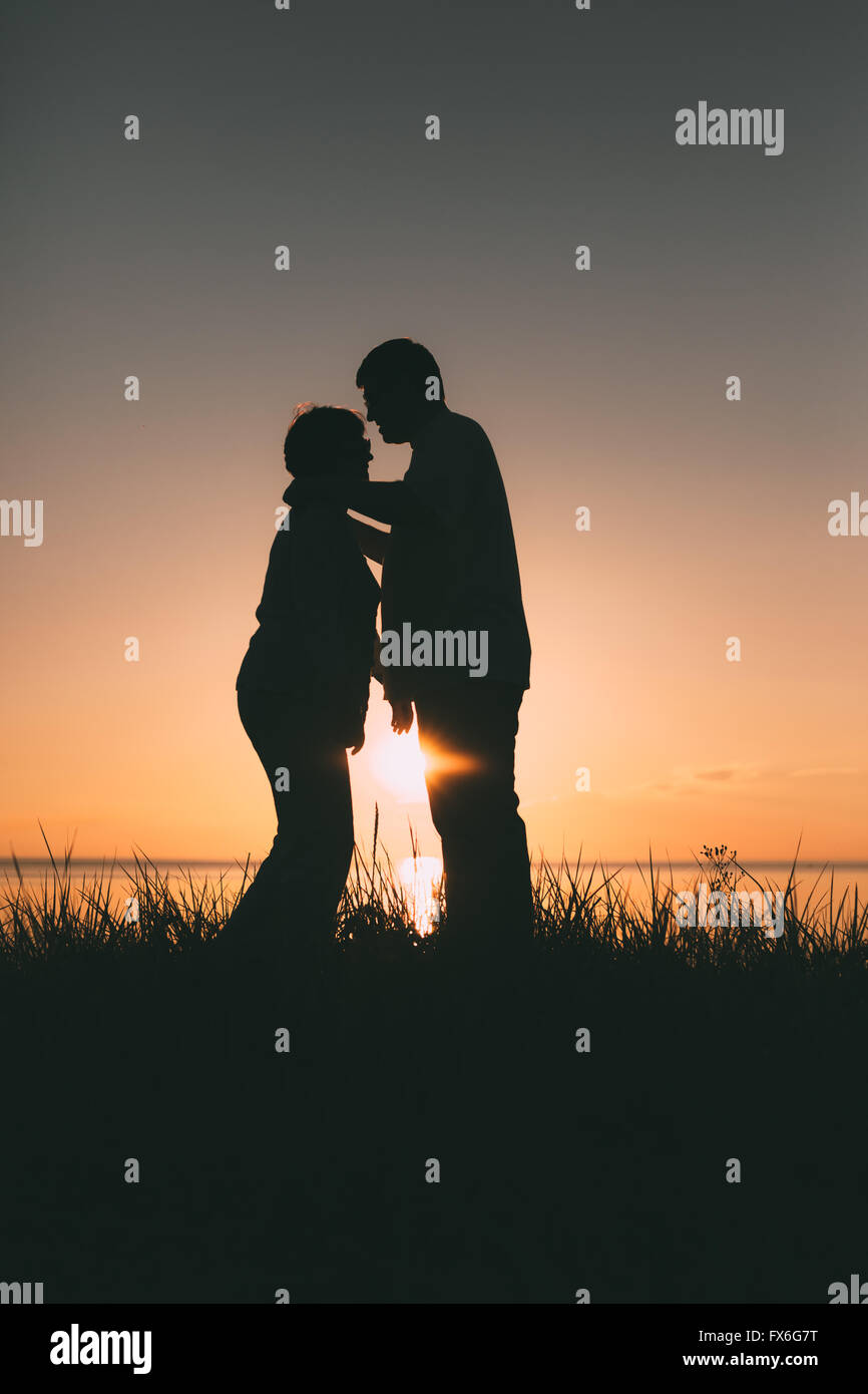 Adult couple silhouettes at sunset Stock Photo - Alamy