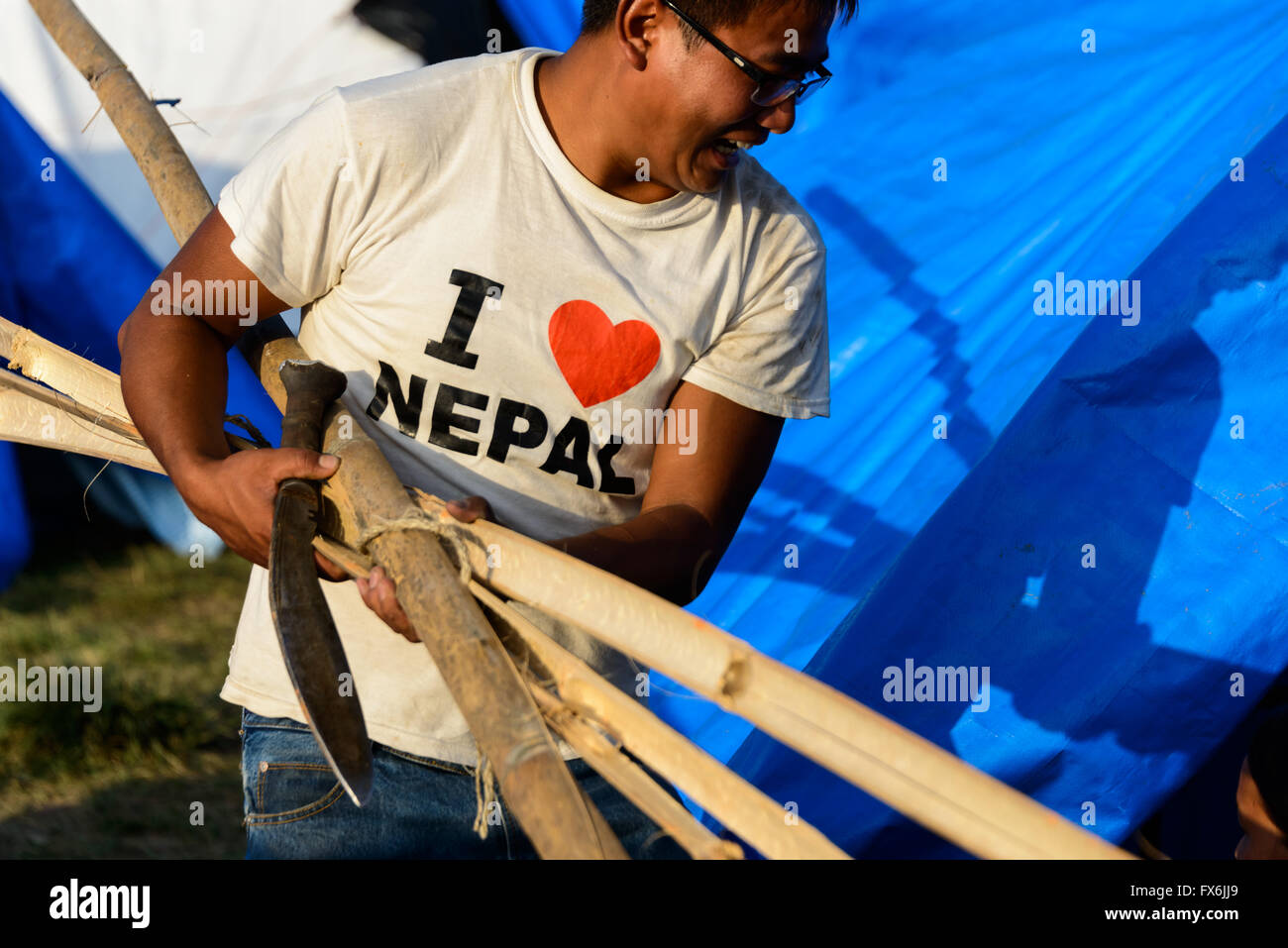 Kathmandu, Nepal - 12 May 2015: Man builds a tent in the Chuchepati area of Kathmandu, after the 7.3 magnitude earthquake. Stock Photo