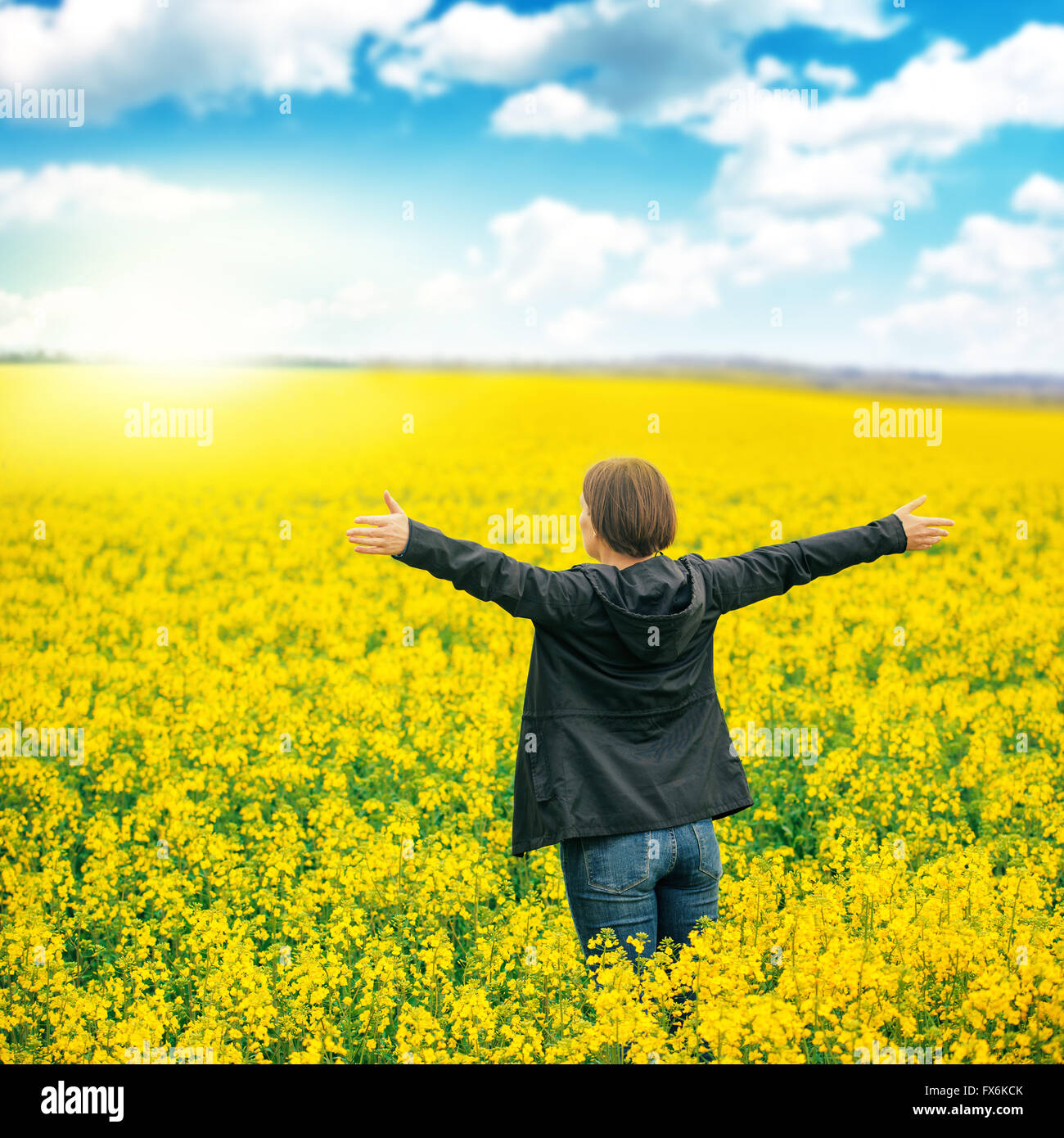 Woman agronomist standing in the field of blooming cultivated rapeseed ...