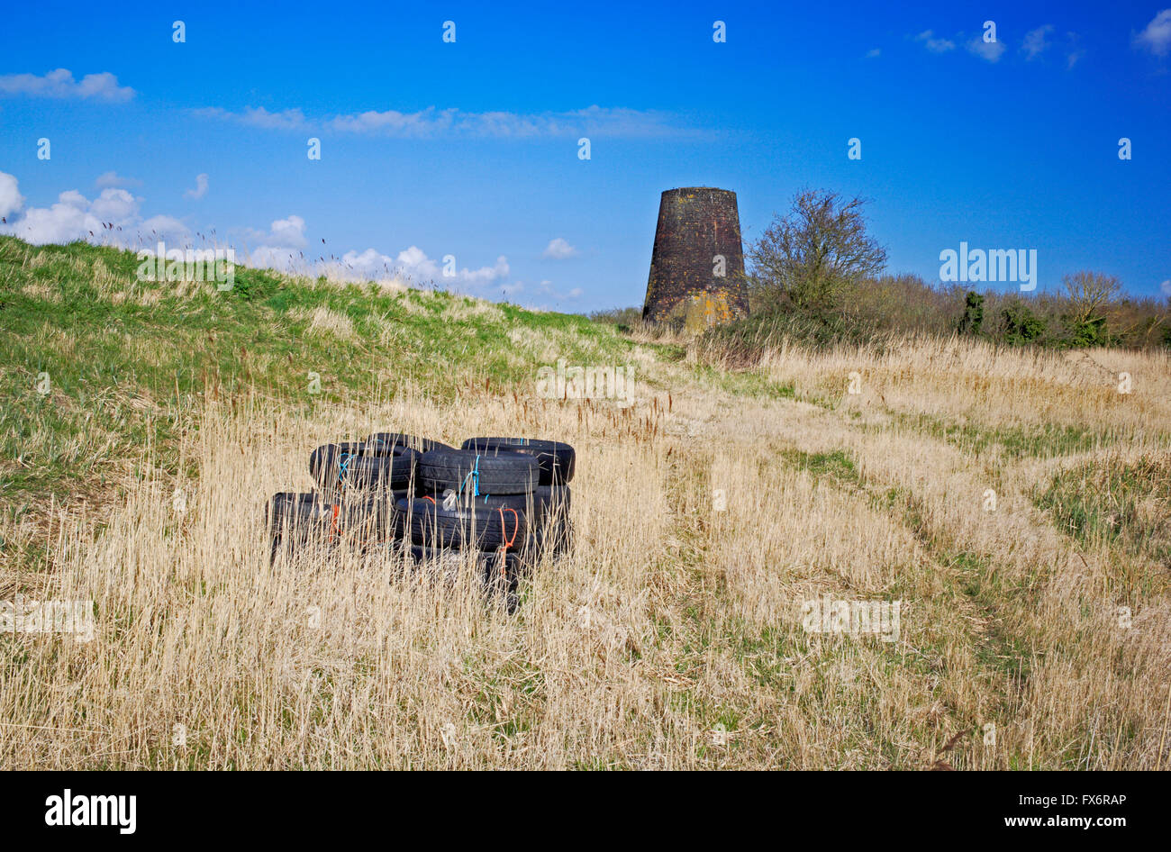 Old Hall Drainage Mill and pile of tyres by farmland at Stokesby, Norfolk, England, United Kingdom. Stock Photo