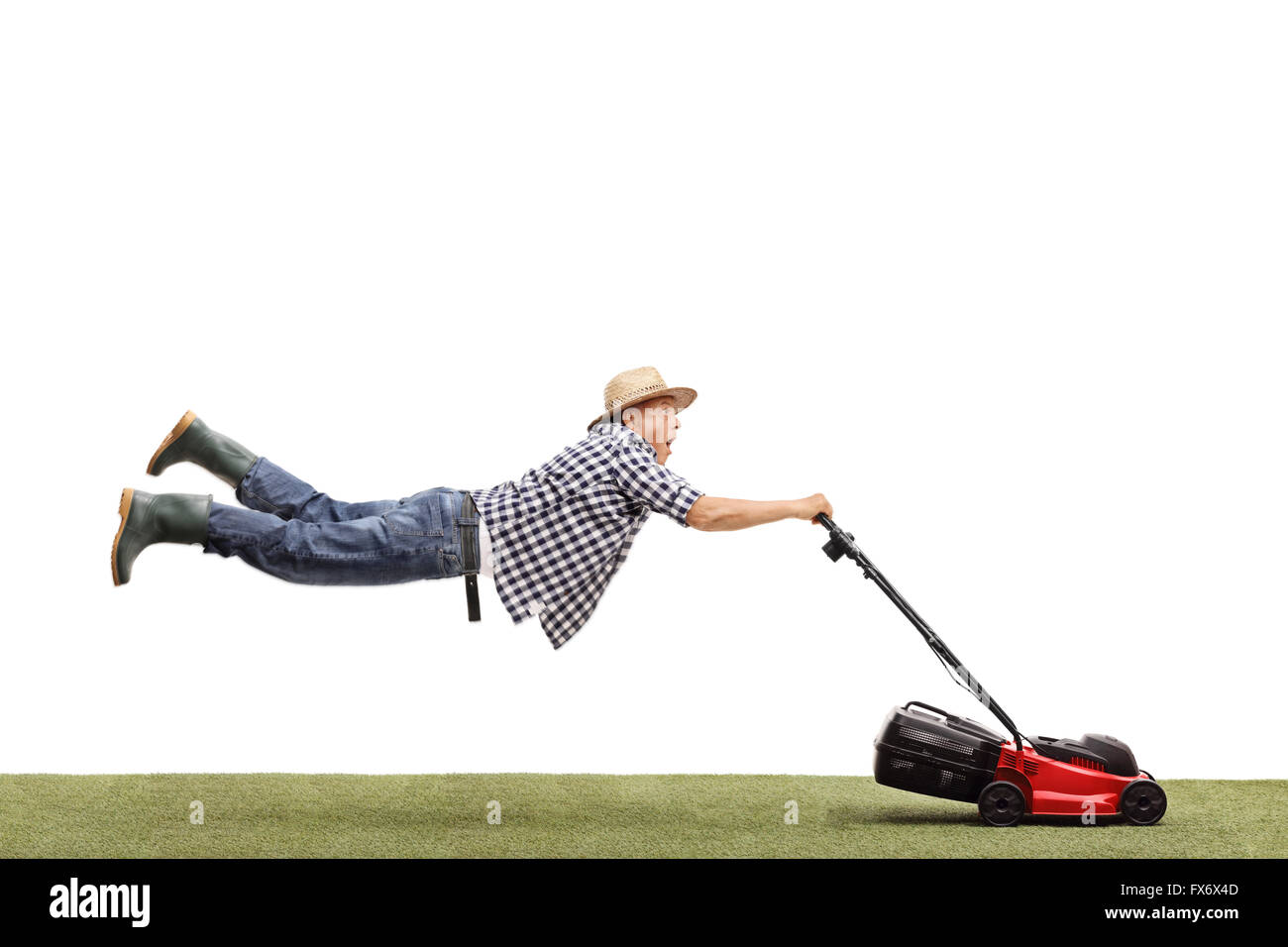 Studio shot of a mature man being pulled by a powerful lawn mower isolated on white background Stock Photo