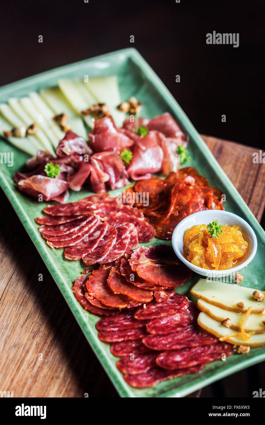 spanish traditional smoked meats serrano ham chorizo and cheese platter starter dish with quince jam and bread Stock Photo