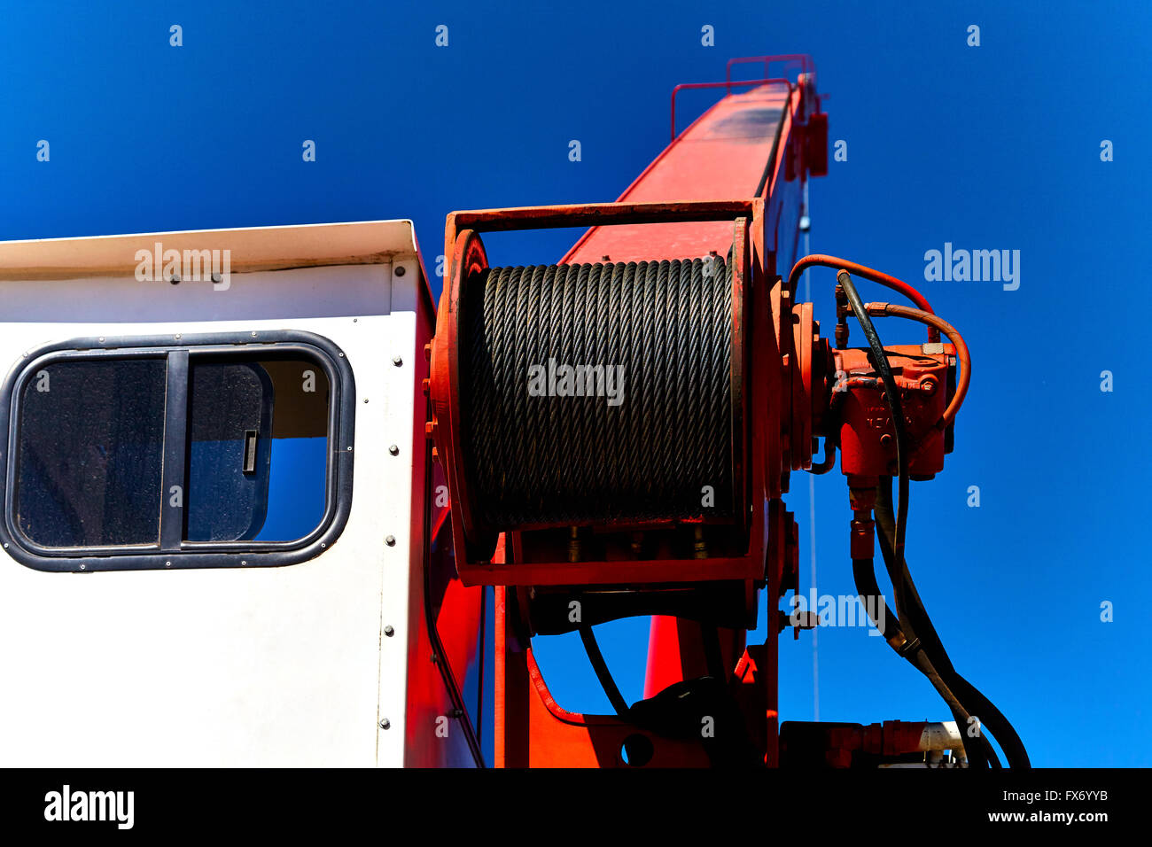 Close up of steel cable and boom with cabin on a crane against blue sky