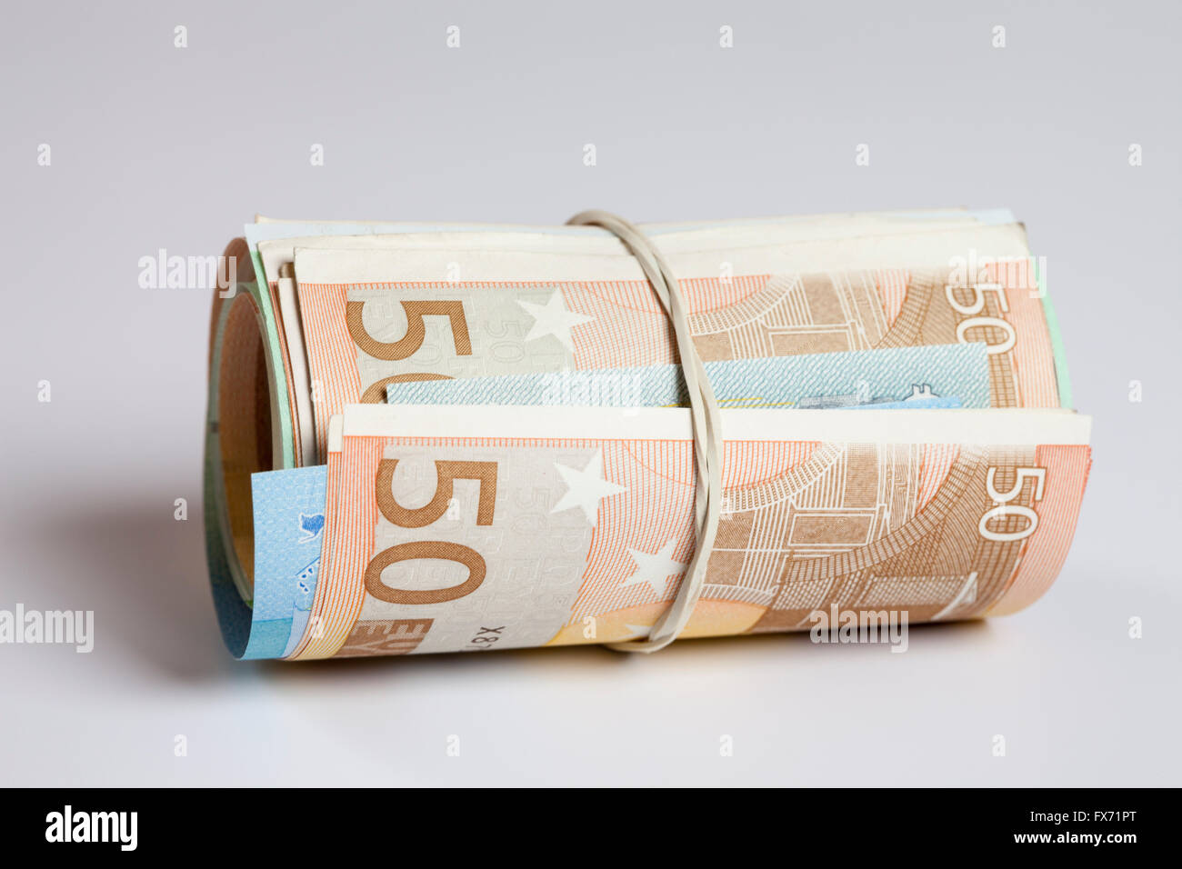 Roll of money with rubber band, multiple bank notes, Euros Stock Photo