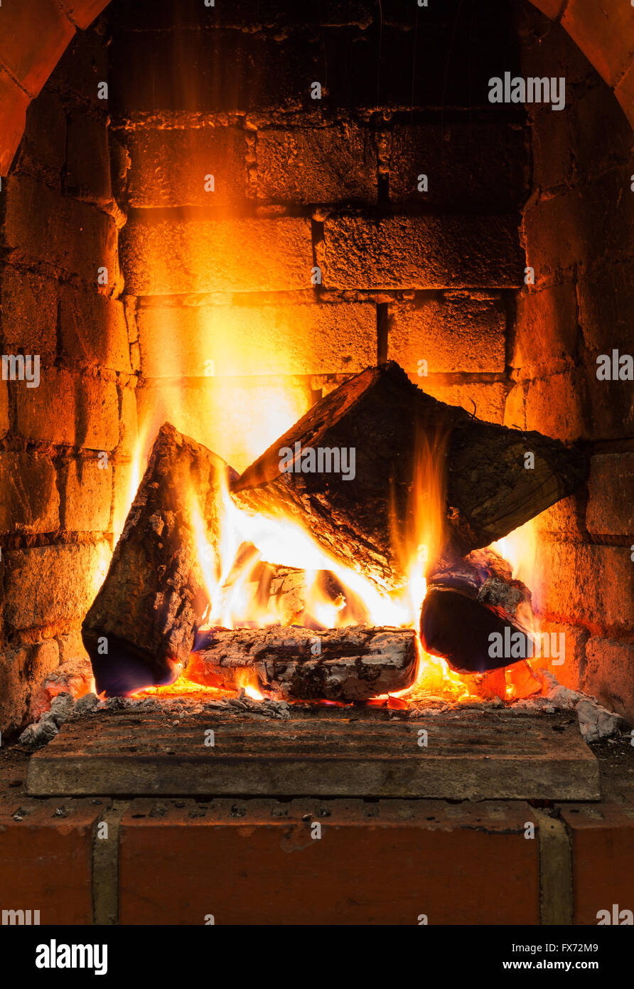 burning firewood in fire-box of fireplace in country cottage Stock Photo