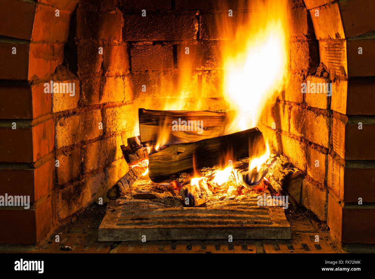 burning firewood in brick fireplace in country cottage Stock Photo