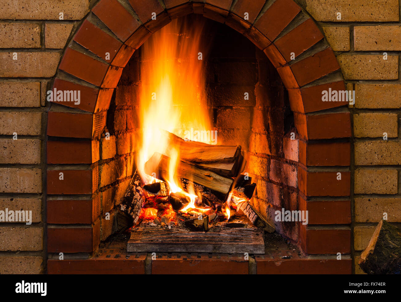 tongues of fire in indoor brick fireplace in country cottage Stock Photo