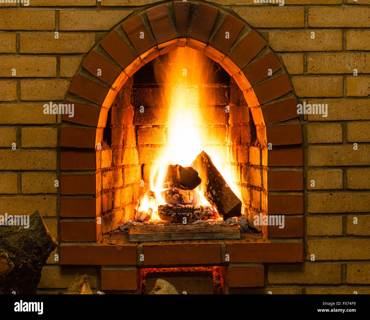 spurts of fire in brick fireplace in country cottage Stock Photo
