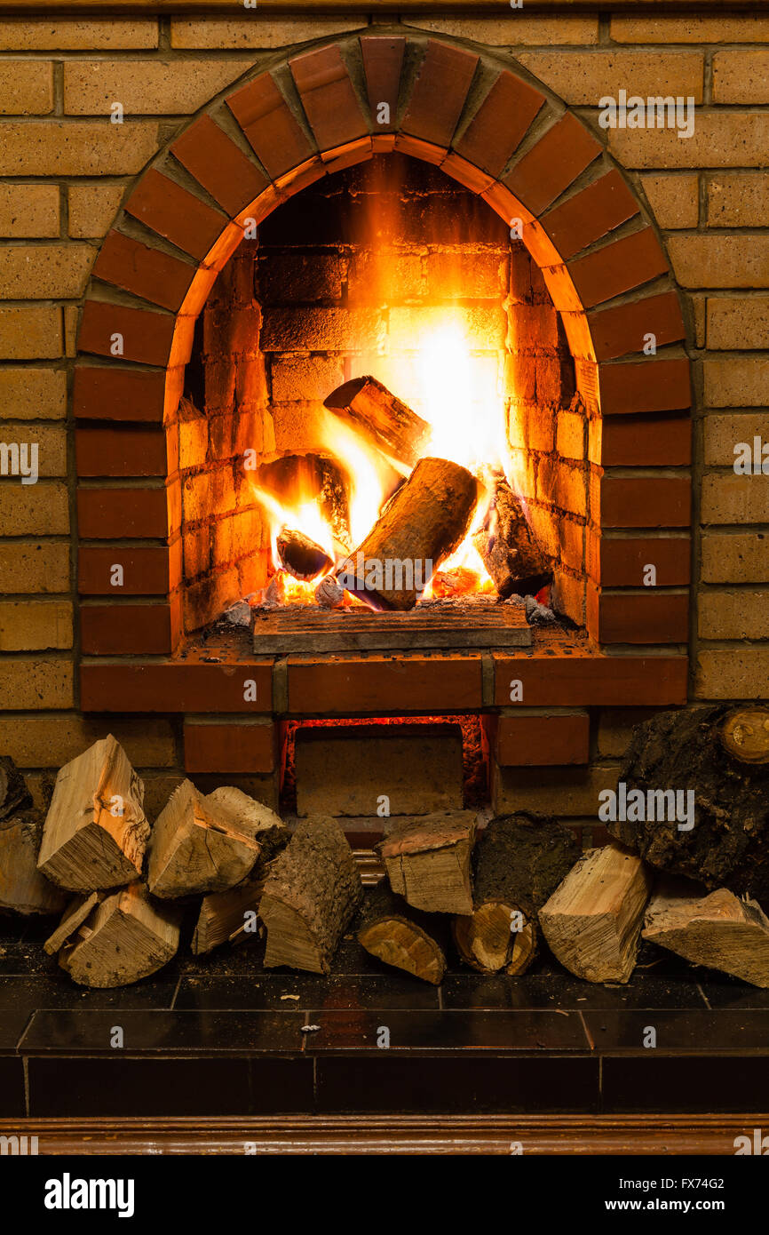 wood and fire in fireplace in country cottage Stock Photo