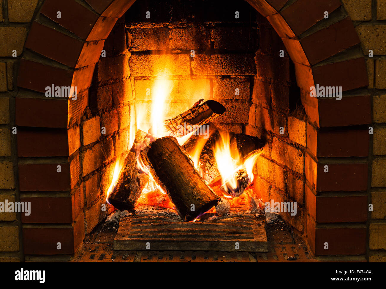 burning wooden logs in fire-box of fireplace in country cottage Stock Photo