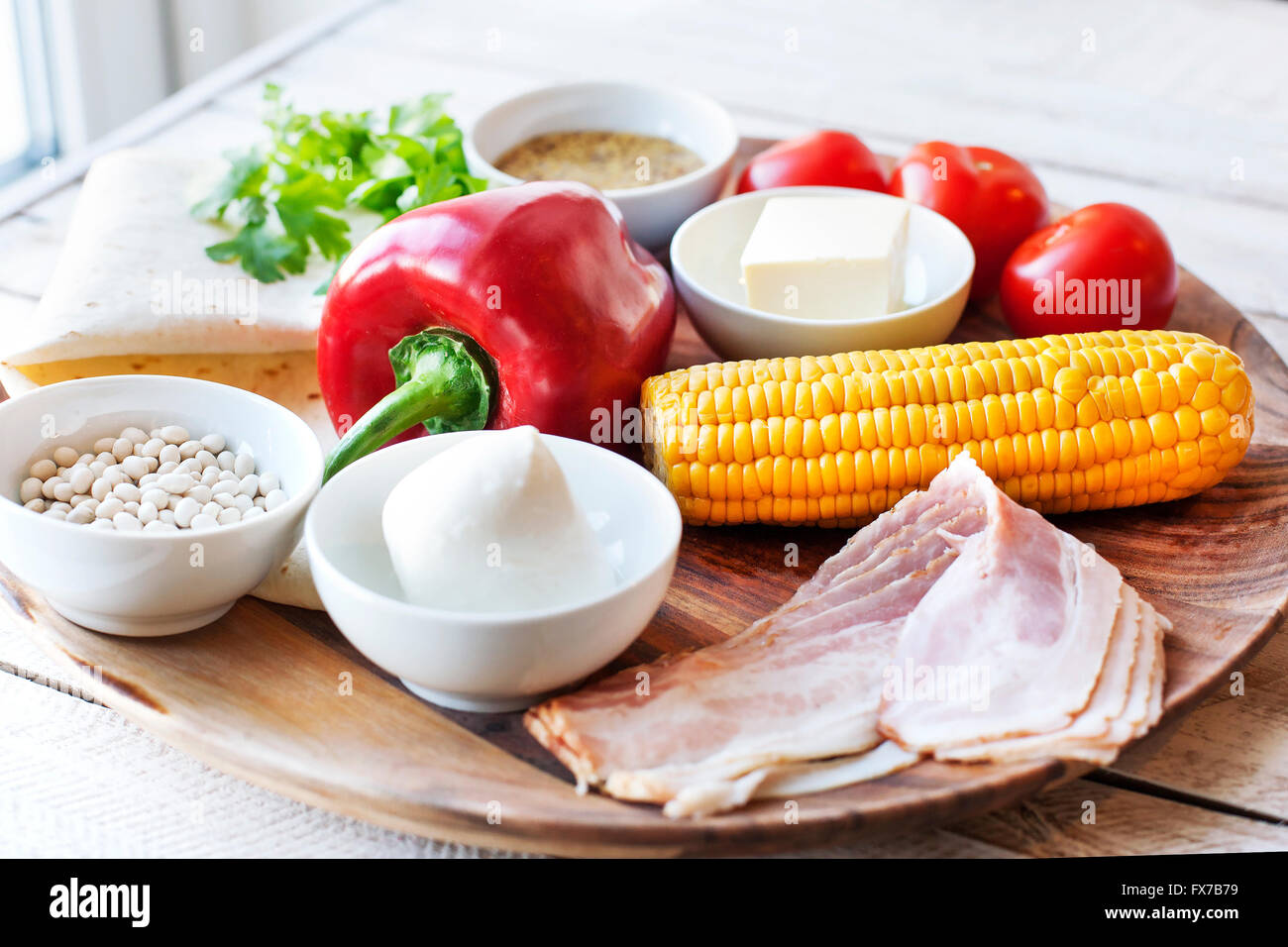 Ingredients for cooking Mexican Quesadilla wrap with vegetables, corn, sweet pepper and sauces on the parchment and table. horiz Stock Photo