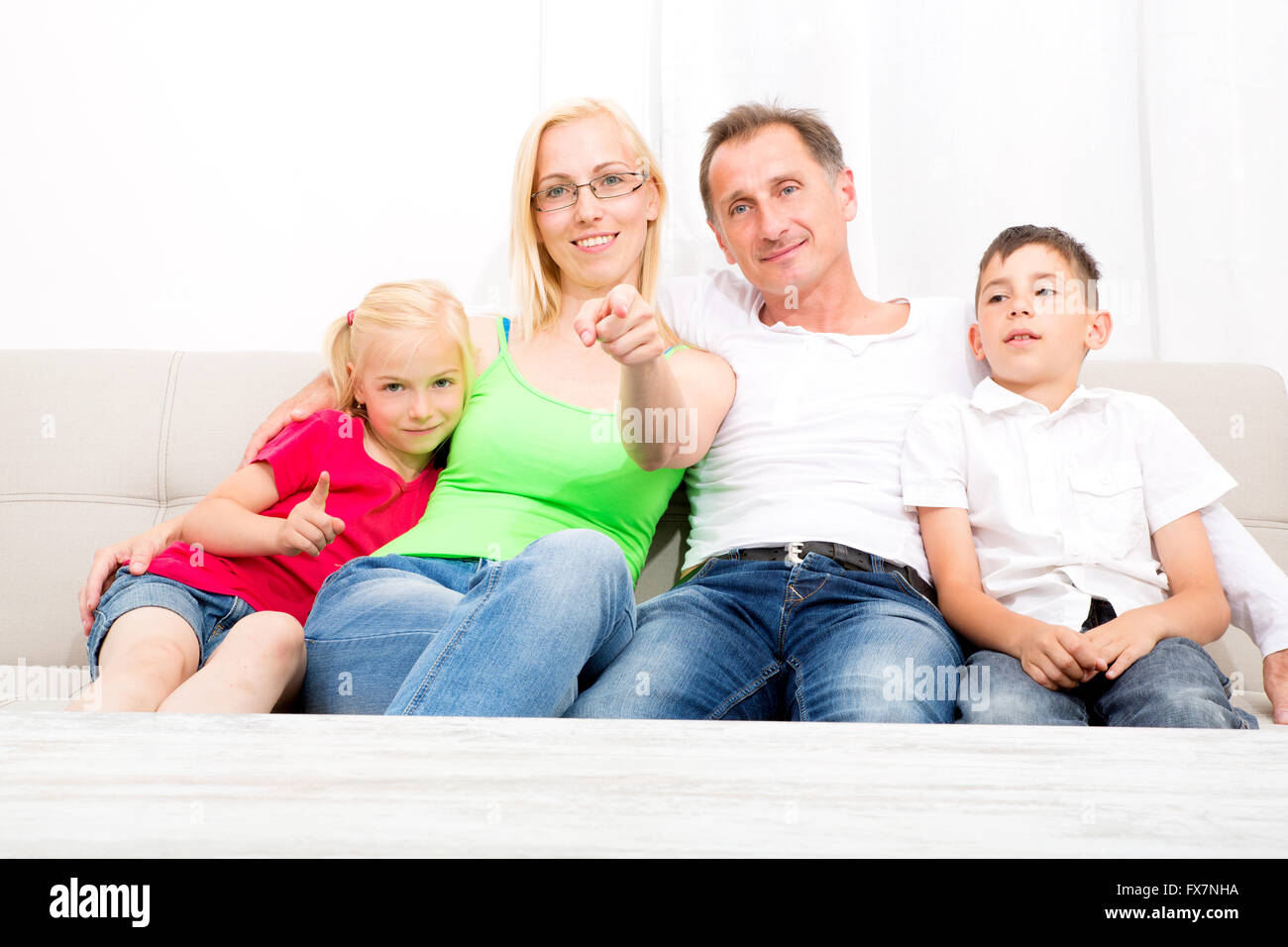 Happy family sitting together on the couch Stock Photo - Alamy